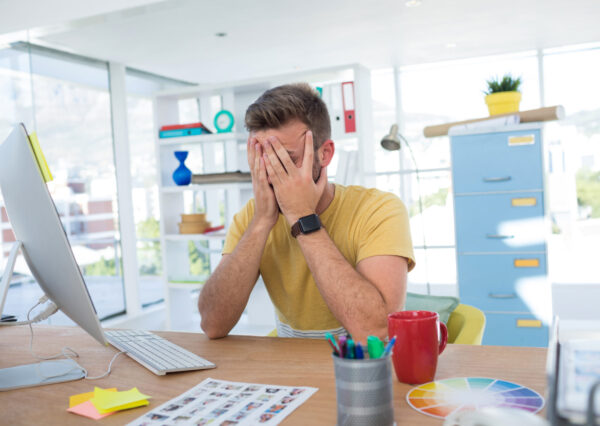 Depressed male executive working on computer in the office